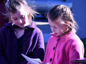 A girl reads during the tree planting ceremony